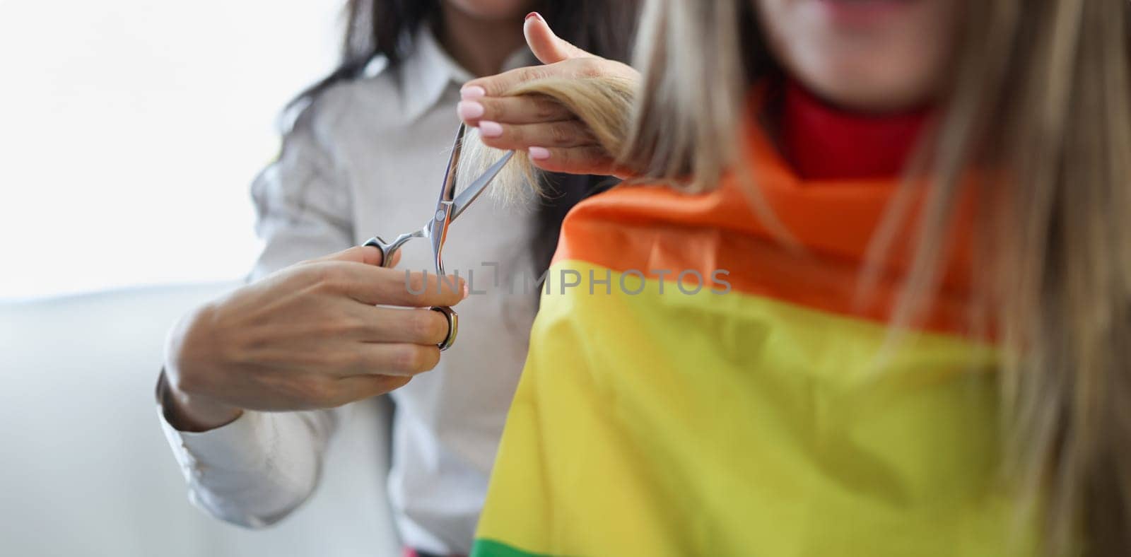 Woman hairdresser cutting ends of client hair with scissors closeup by kuprevich