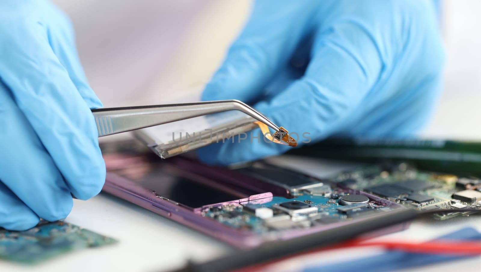 Master repairman inserting microchip into mobile phones closeup by kuprevich