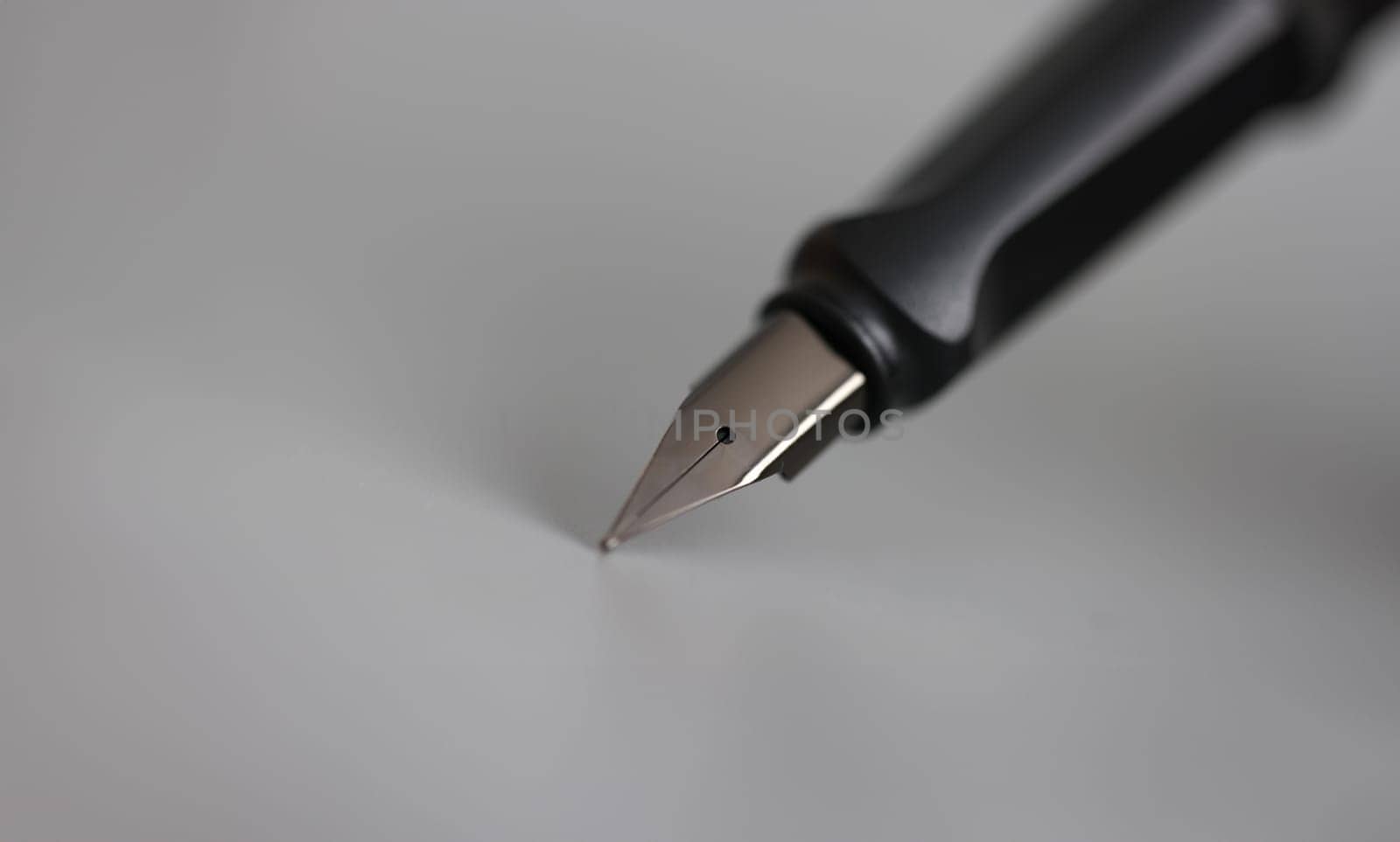 Closeup of metal ink pen head on gray background by kuprevich