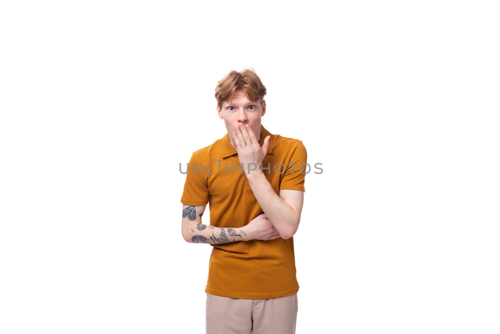 young smart guy with red hair stands thoughtfully on a white background with copy space by TRMK