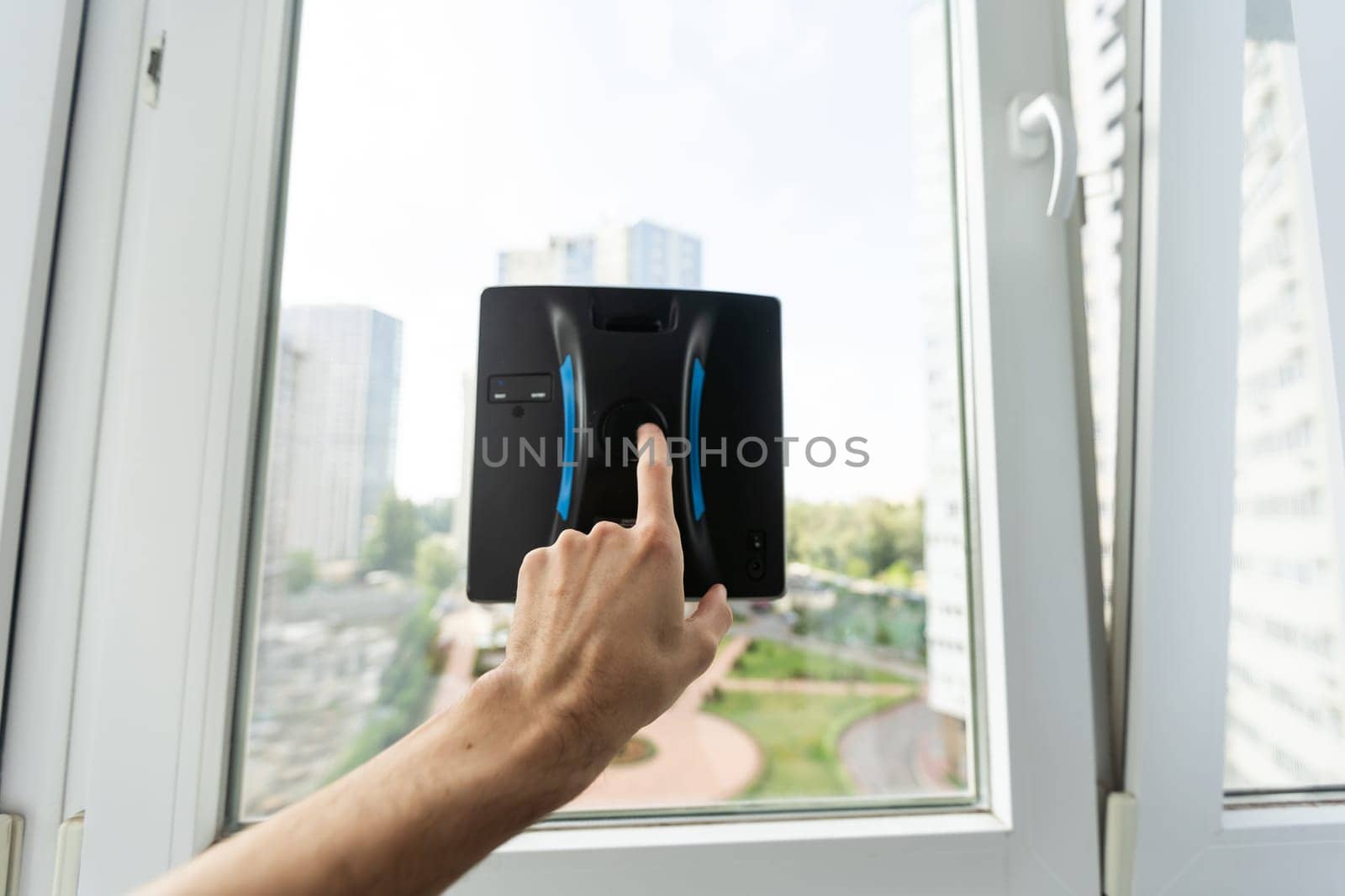 Crop of smart vacuum cleaner washing windows. Home appliance and technology concept. High quality photo