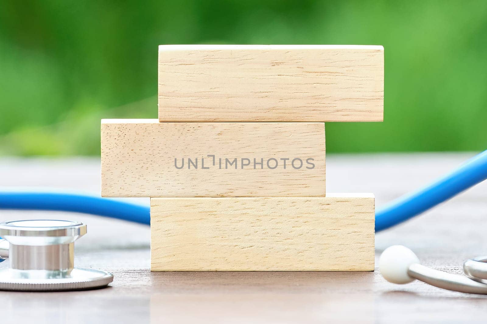 Wooden bars on a green background, a stethoscope next to it. Free space for copying