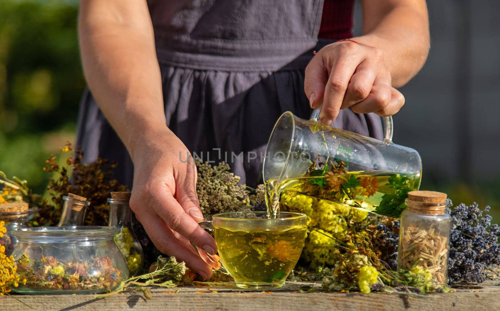 A woman brews herbal tea. Selective focus. Nature.