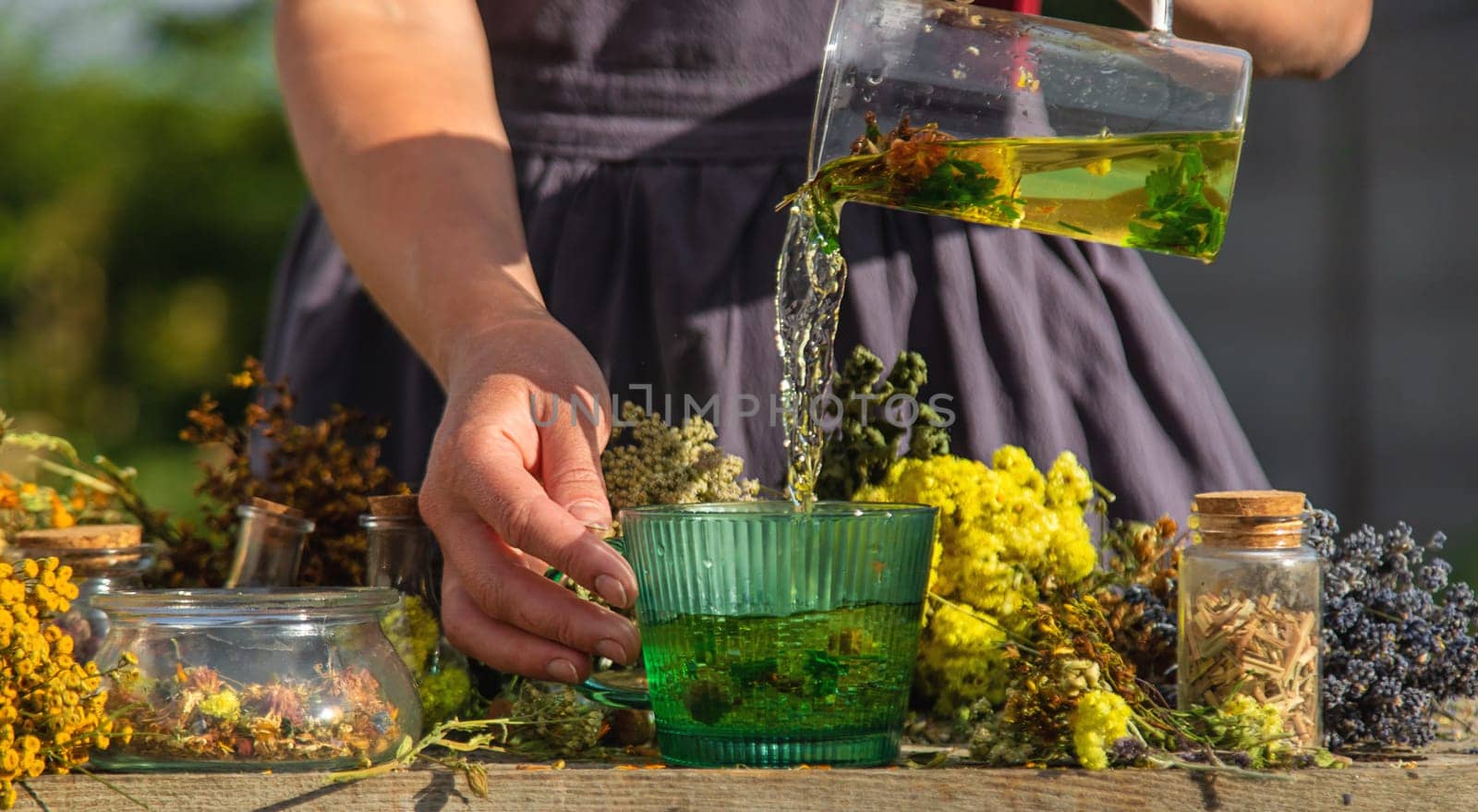 A woman brews herbal tea. Selective focus. Nature.