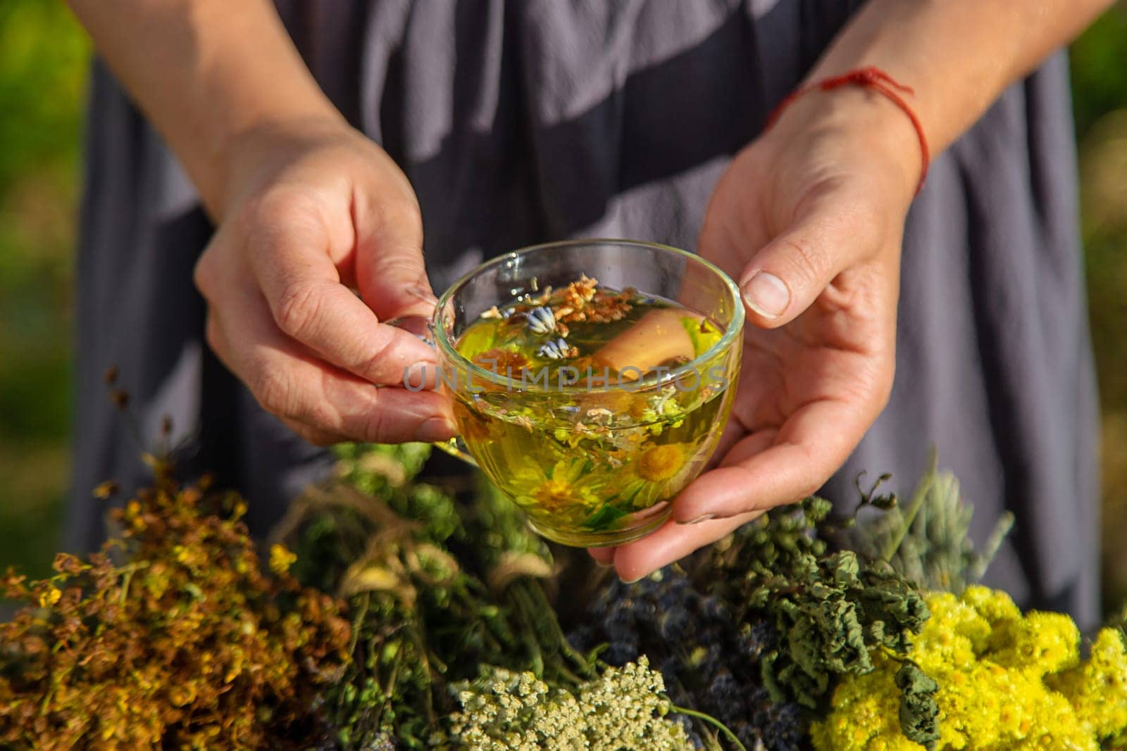 A woman brews herbal tea. Selective focus. Nature.