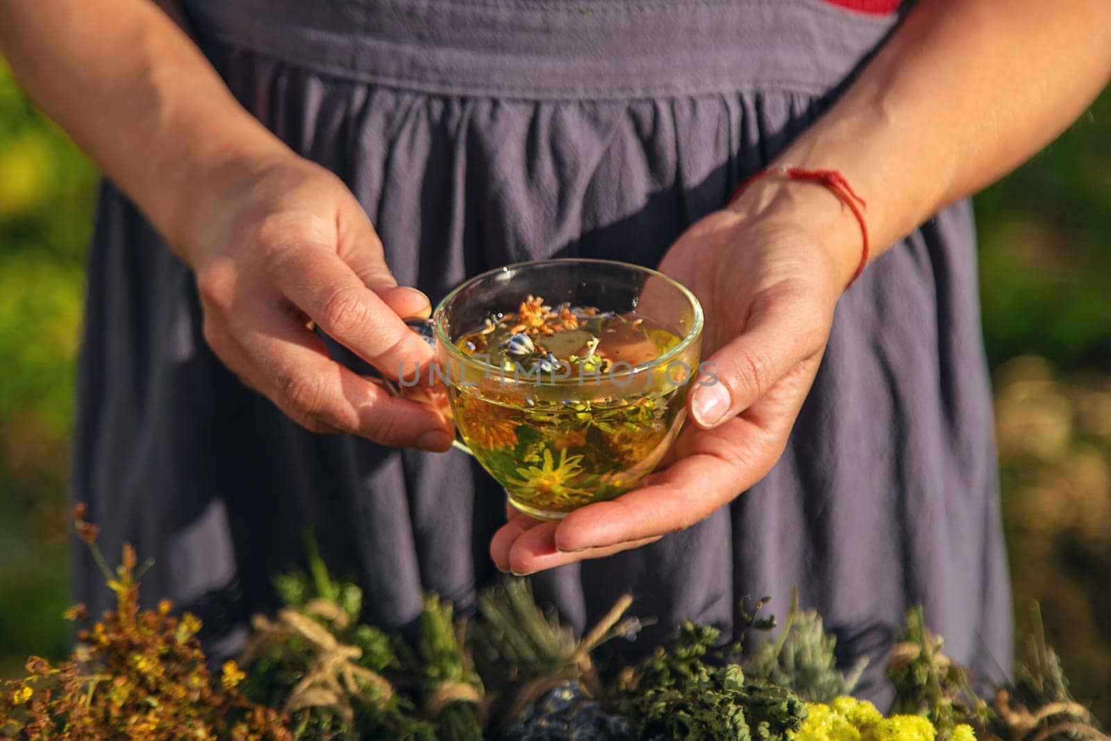 A woman brews herbal tea. Selective focus. Nature.