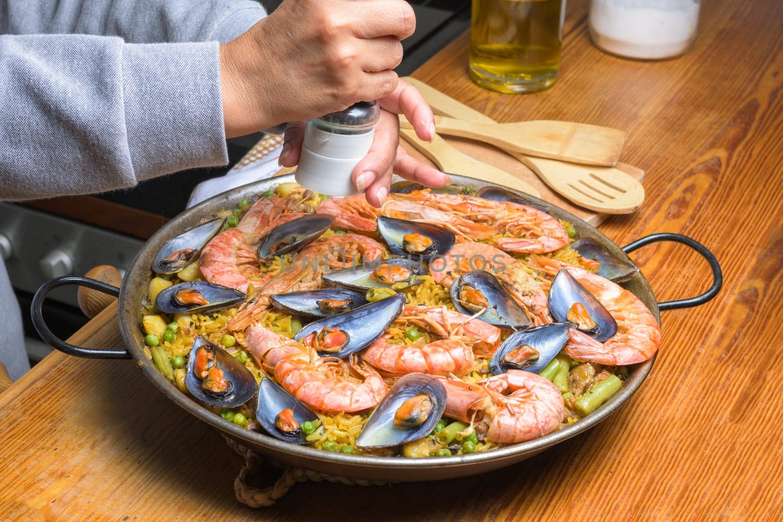 Seasoning a seafood paella with salt, a step in the cooking process of this flavorful Spanish meal, typical Spanish cuisine, Majorca, Balearic Islands, Spain,
