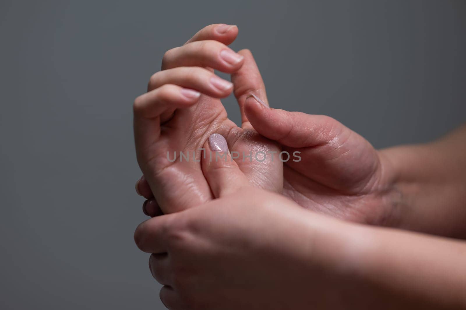 The masseuse massages the client's palms. Close-up of hands at a spa treatment