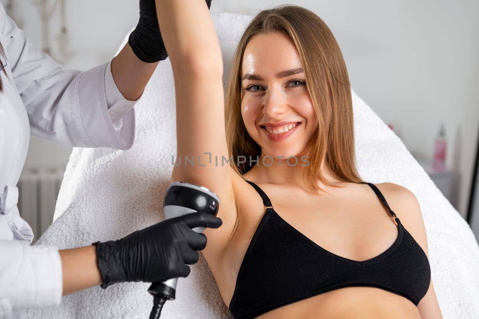 A youthful blonde woman undergoing an ultrasound cavitation procedure at a beauty clinic