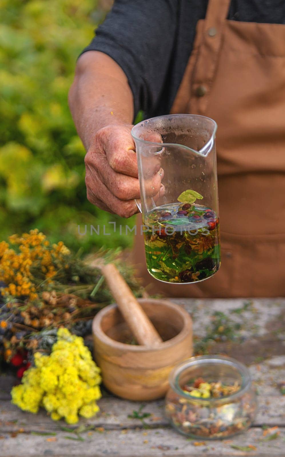 An elderly woman brews herbal tea. Selective focus. Drink.