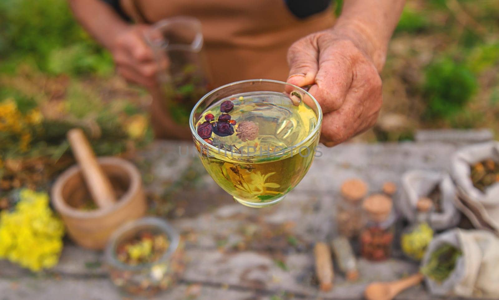 An elderly woman brews herbal tea. Selective focus. Drink.