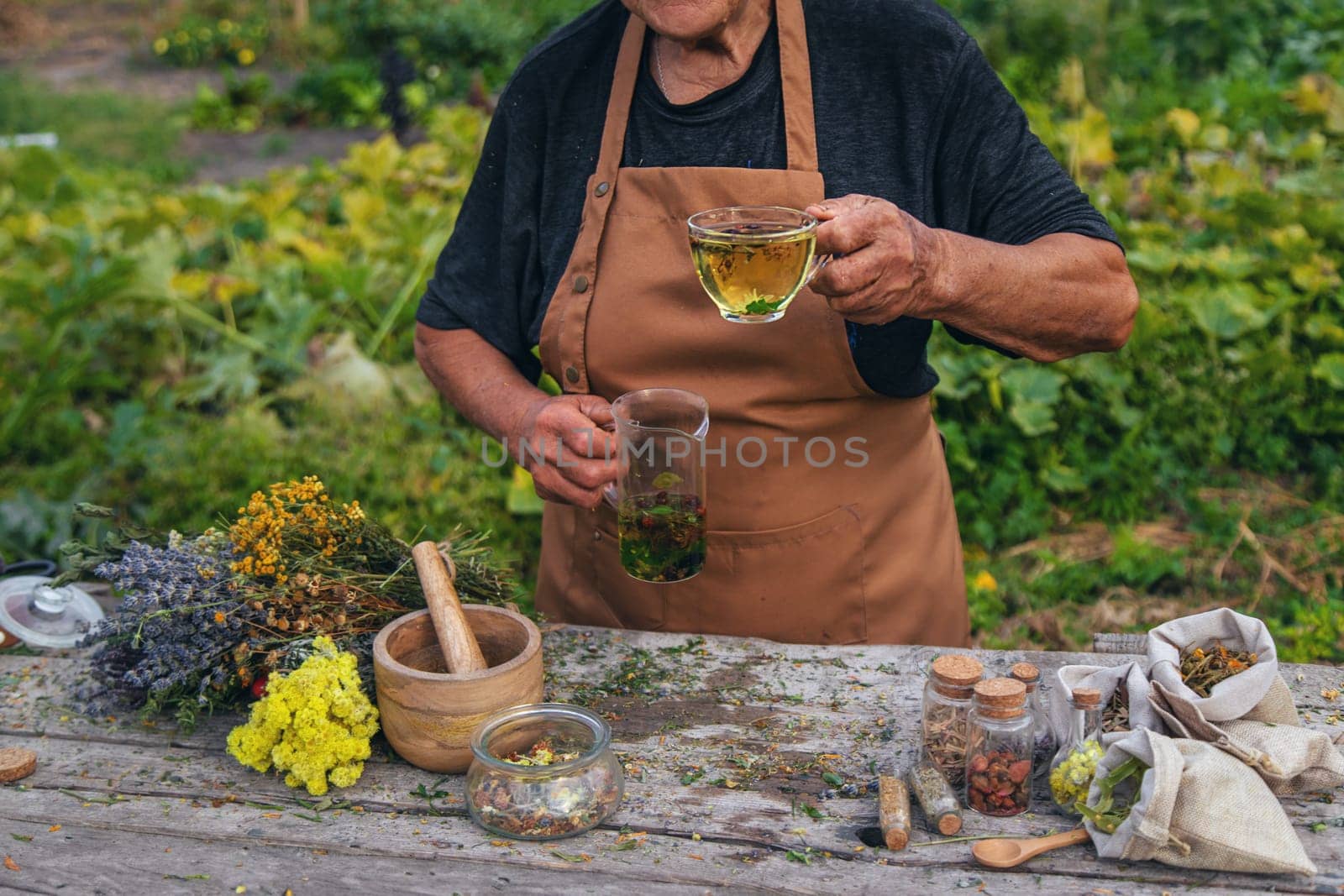 An elderly woman brews herbal tea. Selective focus. by yanadjana