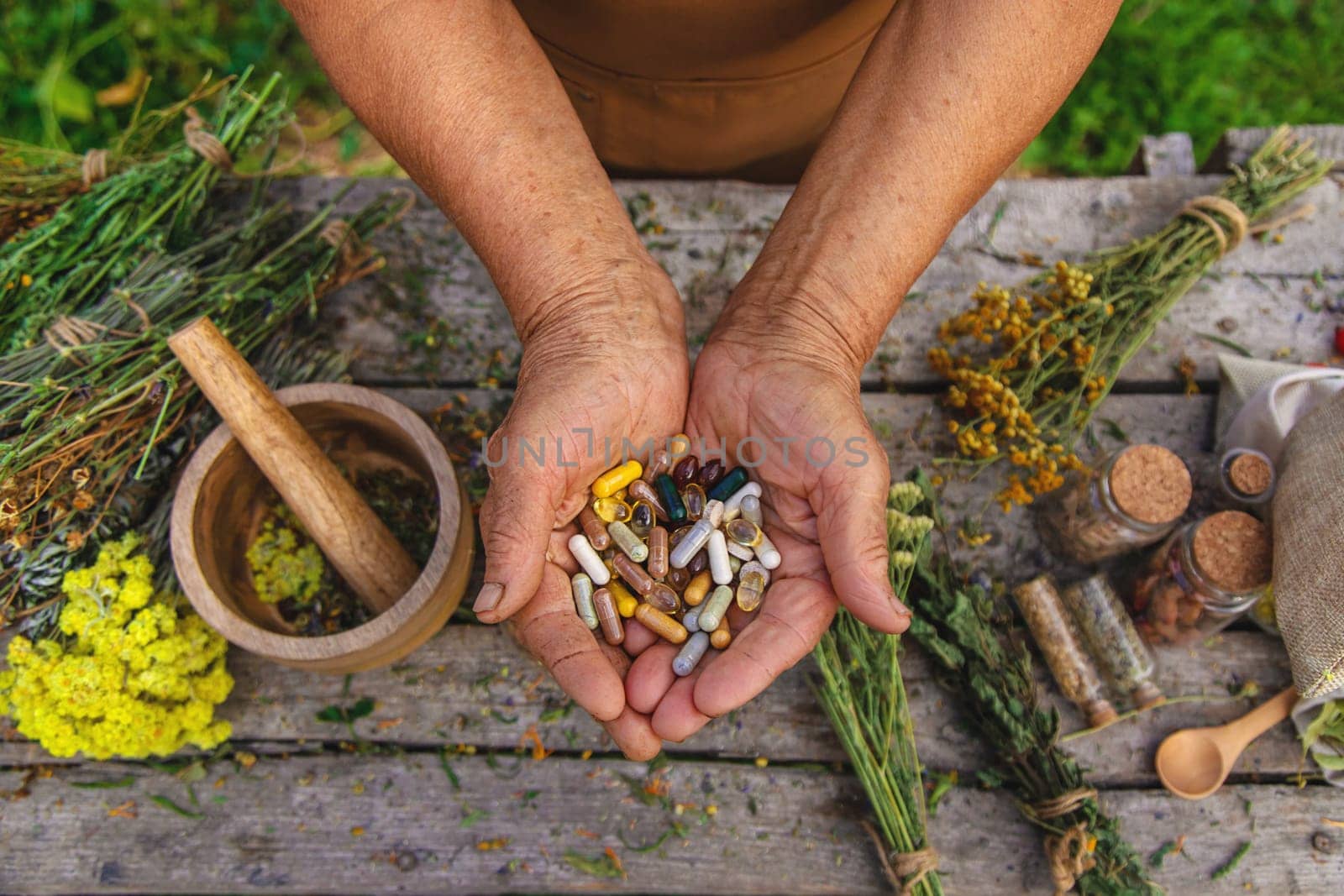 An elderly woman holds supplements in her hands. Selective focus. Nature.