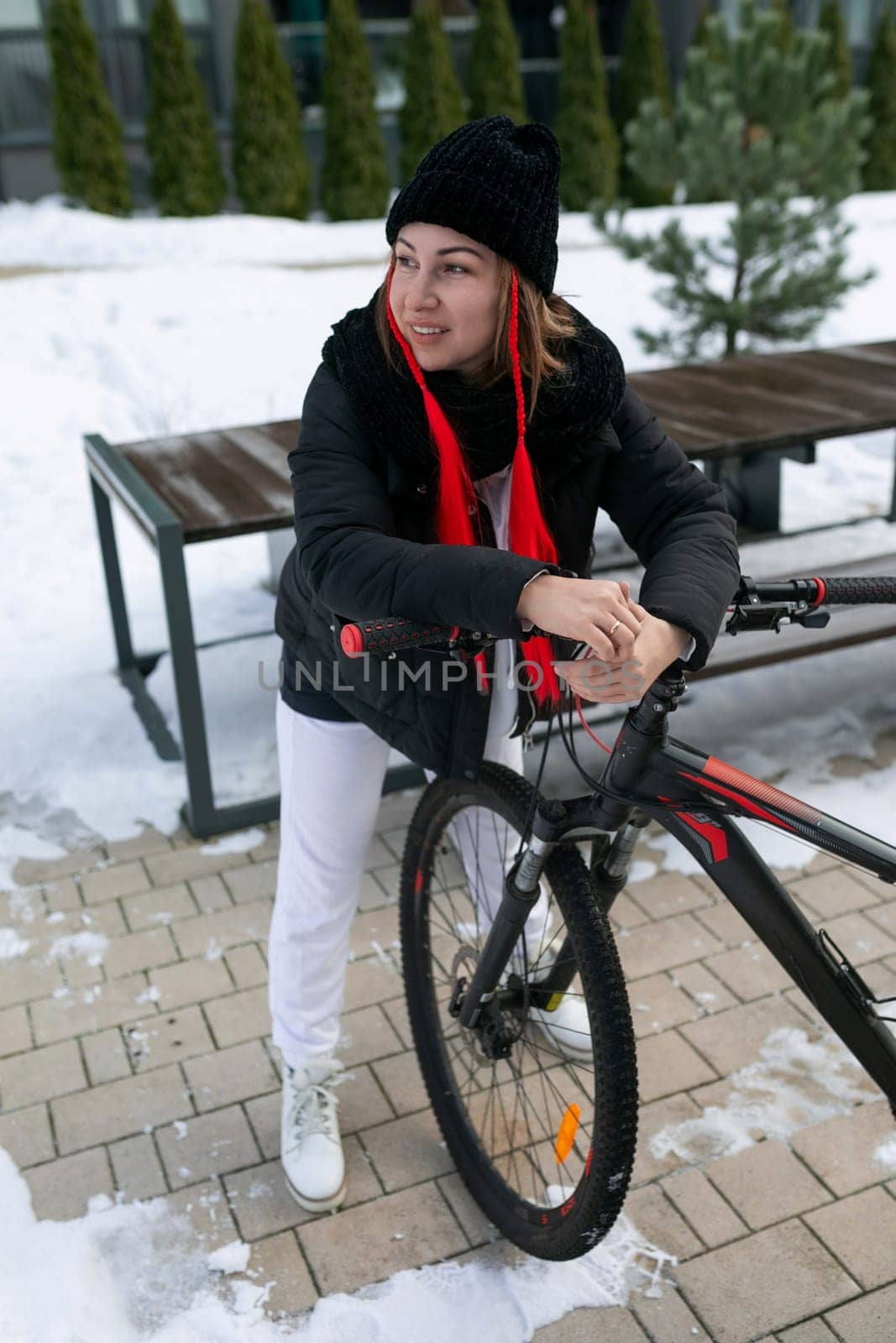 European woman in winter clothes riding a bicycle in winter.