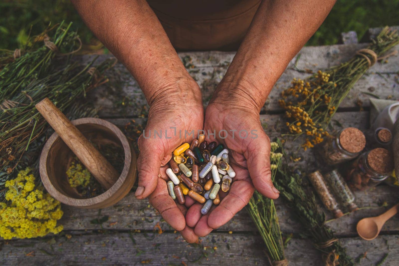 An elderly woman holds supplements in her hands. Selective focus. Nature.