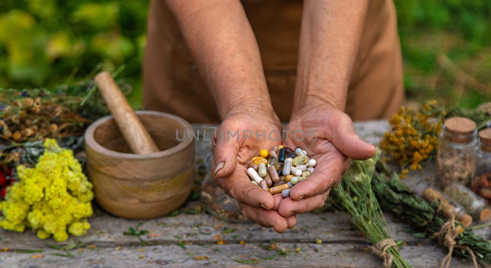 An elderly woman holds supplements in her hands. Selective focus. by yanadjana
