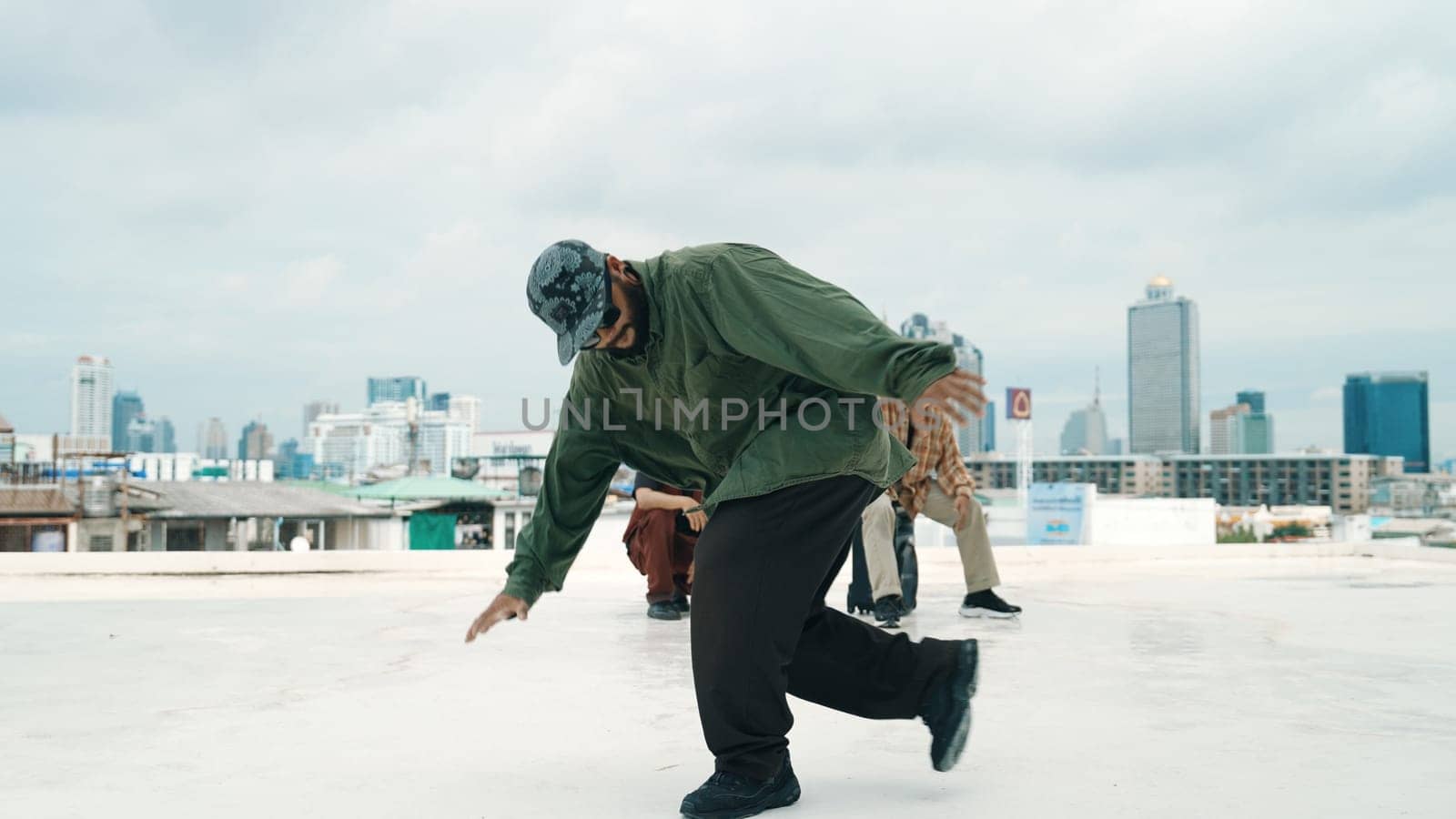 Professional break dance team practice B-boy dance while multicultural friends at rooftop. Young modern dancing group doing hip hop movement. Style,fashion,action. Outdoor sport 2024. Endeavor.