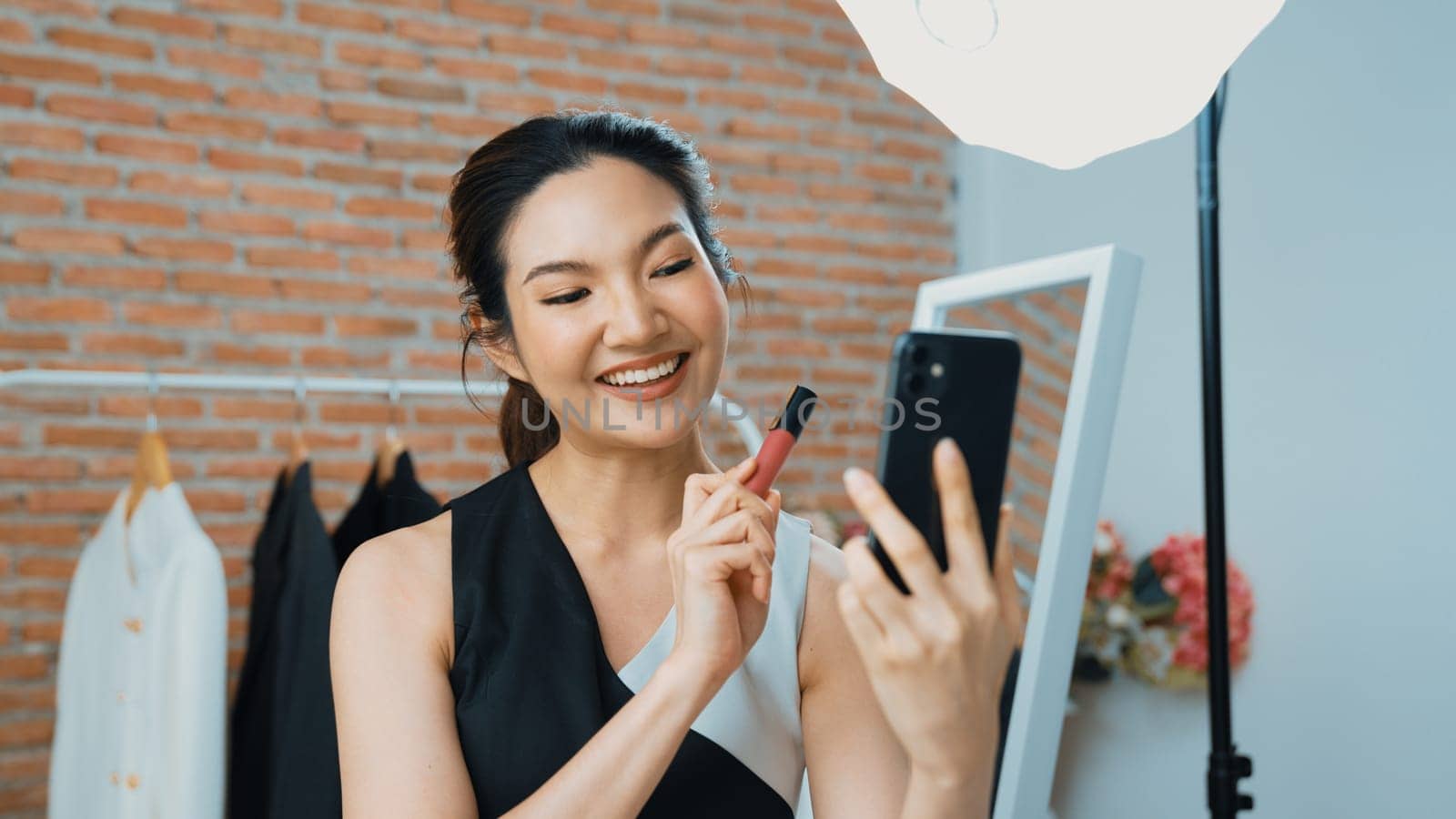 Woman influencer shoot live streaming vlog video review vivancy makeup social media or blog. Happy young girl with cosmetics studio lighting for marketing recording session broadcasting online.