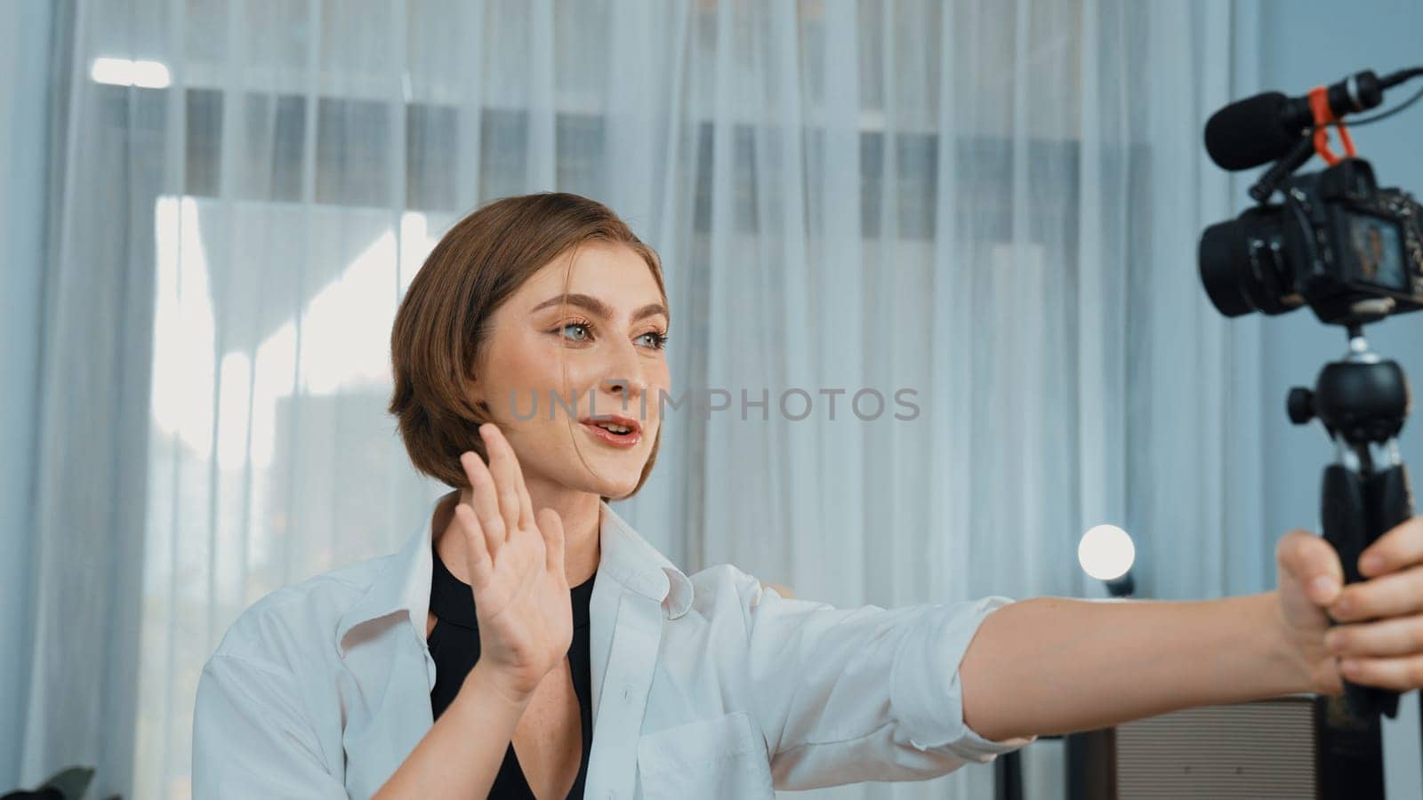 Woman influencer shoot live streaming vlog video review clothes prim social media or blog. Happy young girl with apparel studio lighting for marketing recording session broadcasting online.