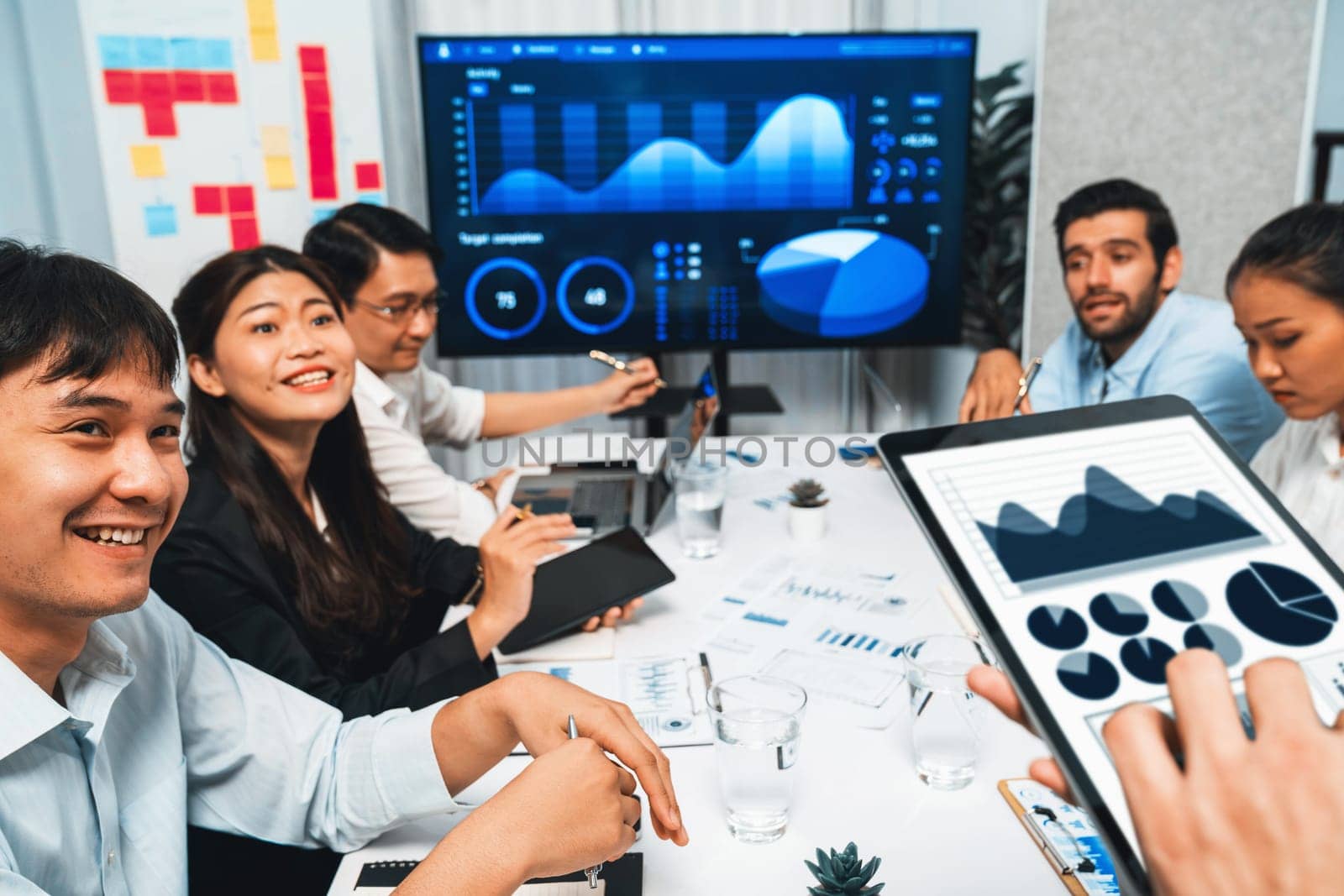 Analyst team uses BI Fintech display tablet to analyze financial data . Business people analyze BI software technology dashboard power for insights power into business marketing planning. Prudent
