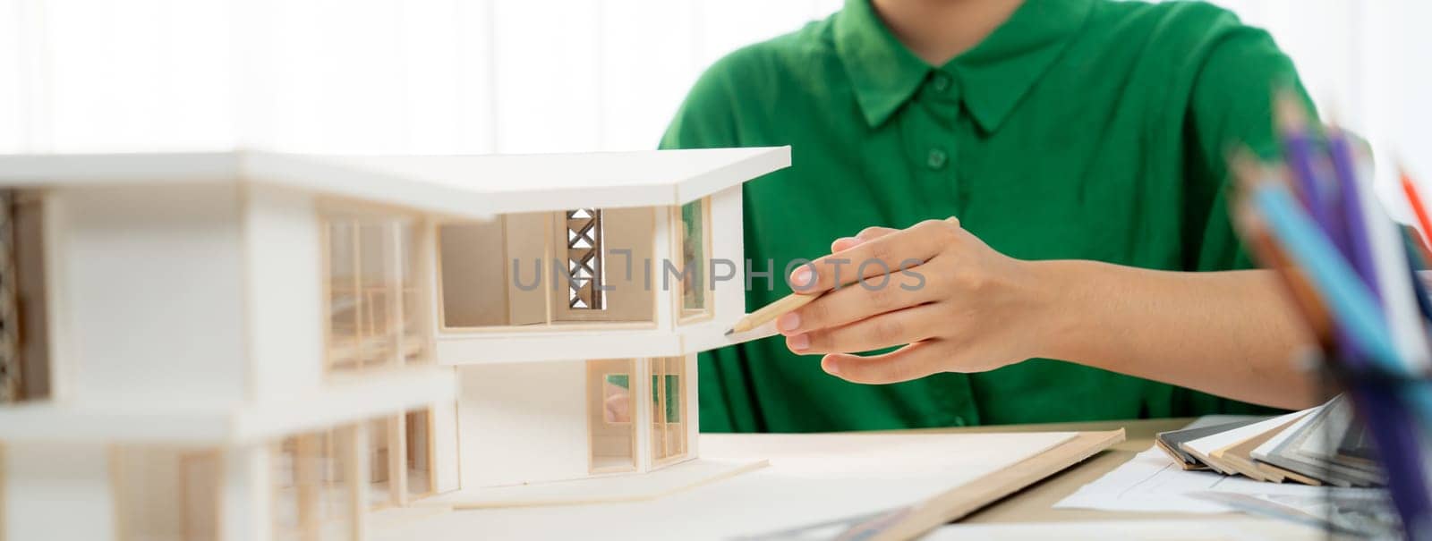 Female professional designer measuring house model with pencil. Variegated. by biancoblue