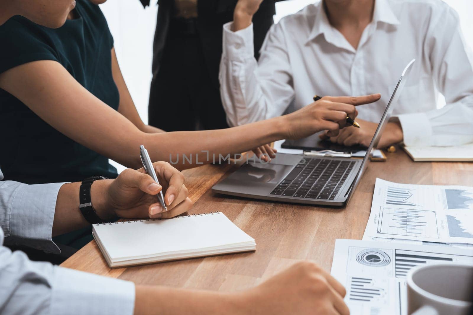 Multiracial analyst team use BI dashboard data to analyze financial report on meeting table. Group of diverse business people utilize data analysis by FIntech for success business marketing. Concord