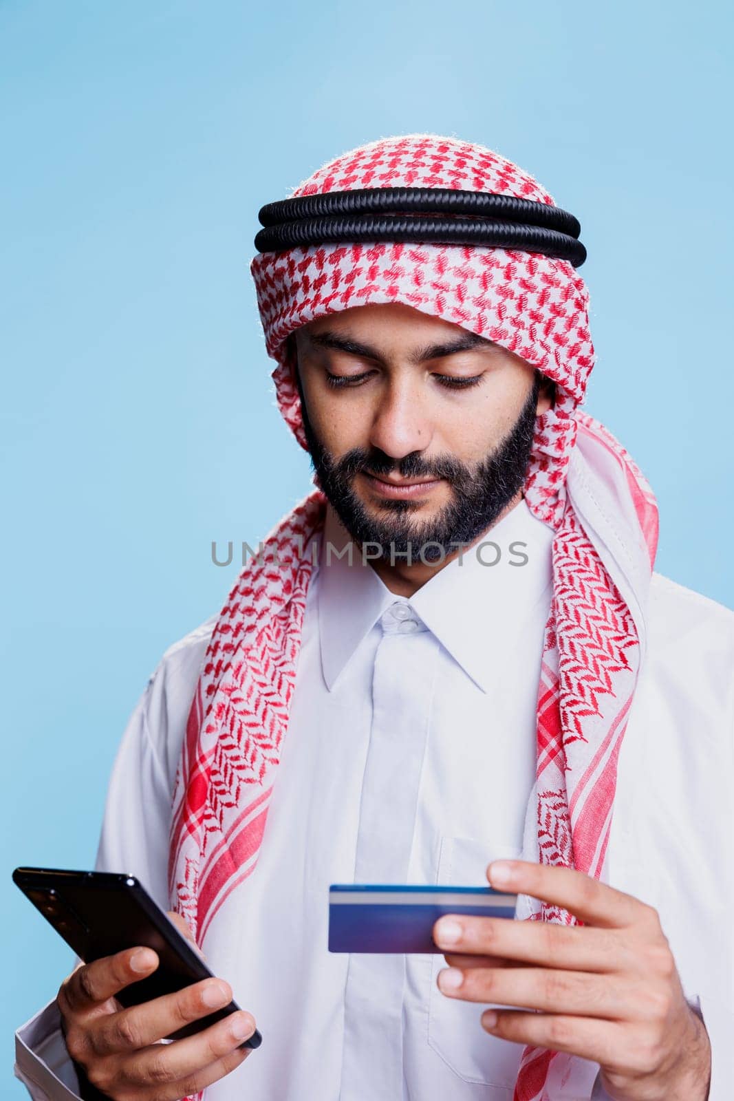 Arab making electronic payment on phone by DCStudio