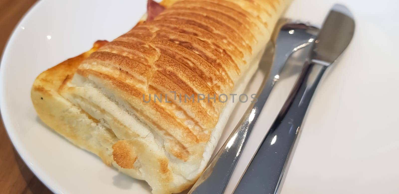Grilled smoked beef mushroom Panini or sandwich served with white plate on the wooden table, in a famous restaurant