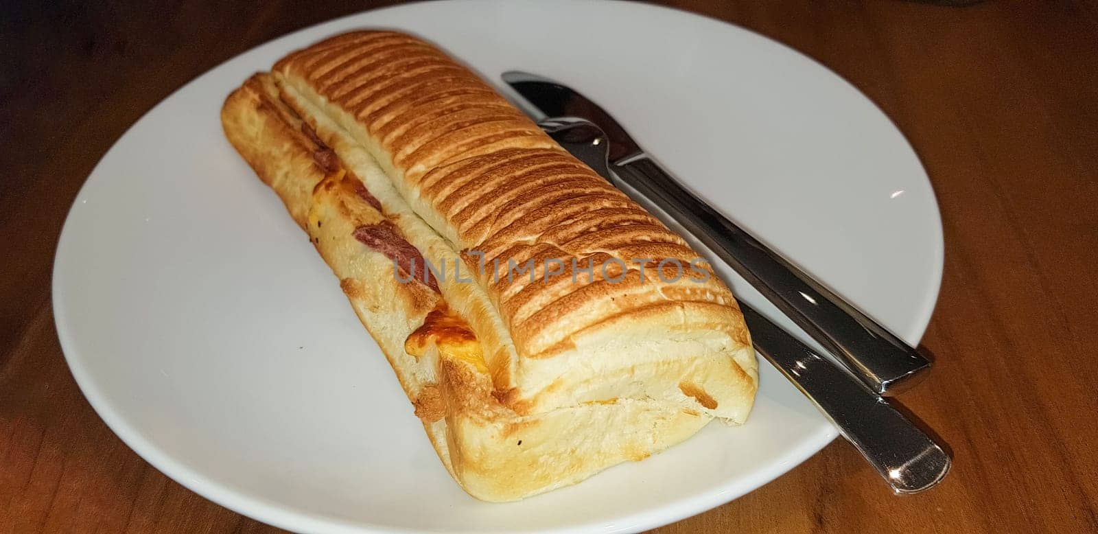 Grilled smoked beef mushroom Panini or sandwich served with white plate on the wooden table, in a famous restaurant