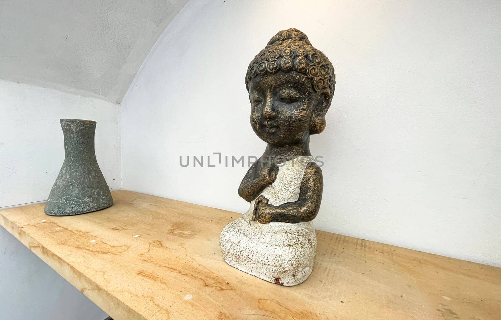 Small statue decorations for table and interior, little buddha statue modern simplistic house environment with several pottery and wooden table