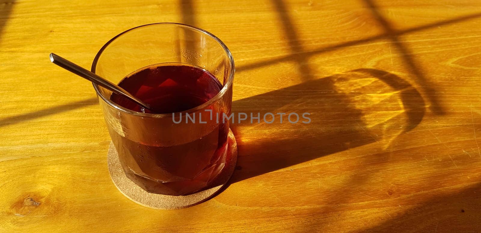 Transparent Glasses with sweet drinks inside with colorful drink, with shadow and table background with ice cubes by antoksena