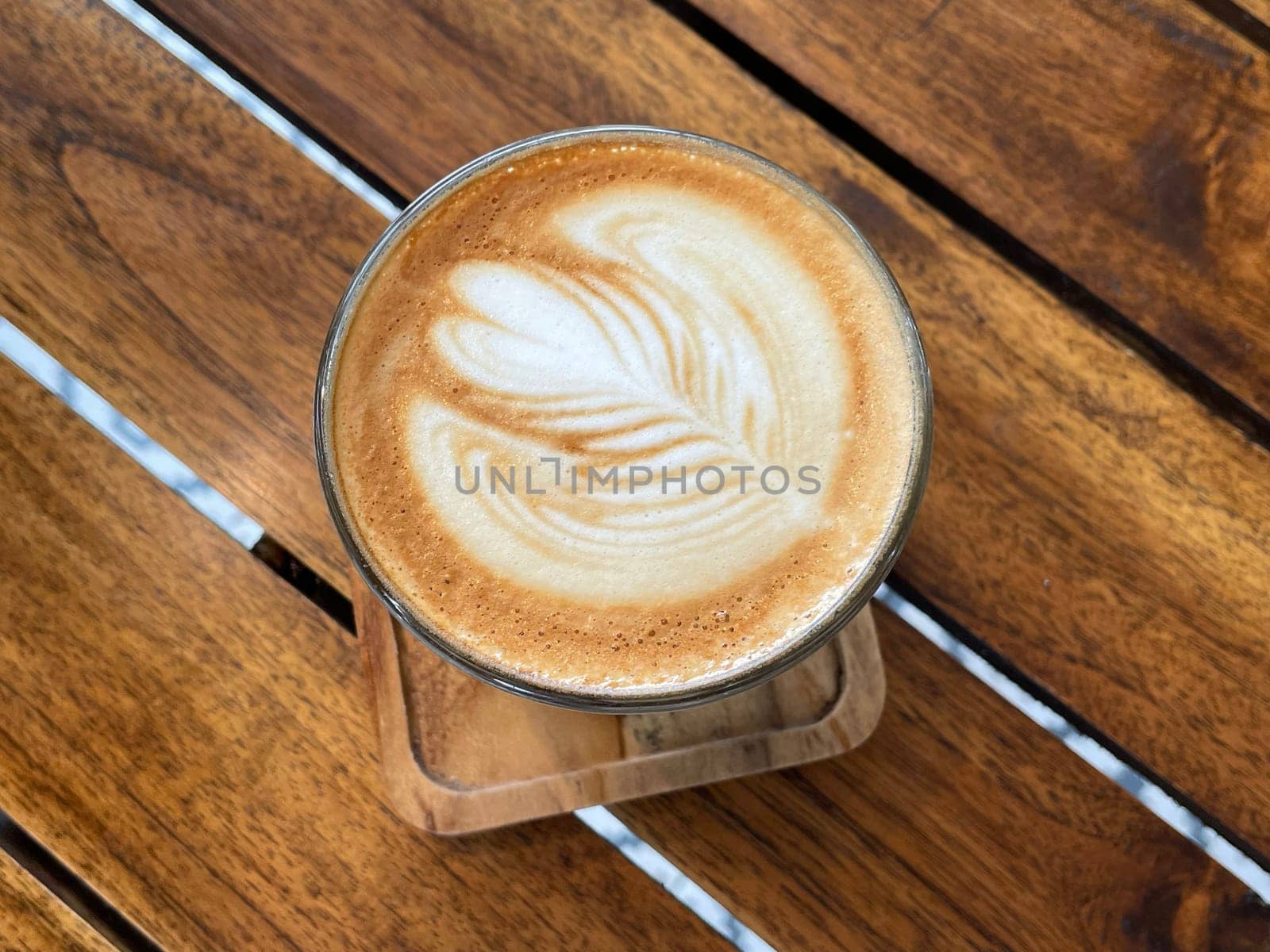 beautiful cup of cappuccino coffee with latte art in the wooden space background by antoksena