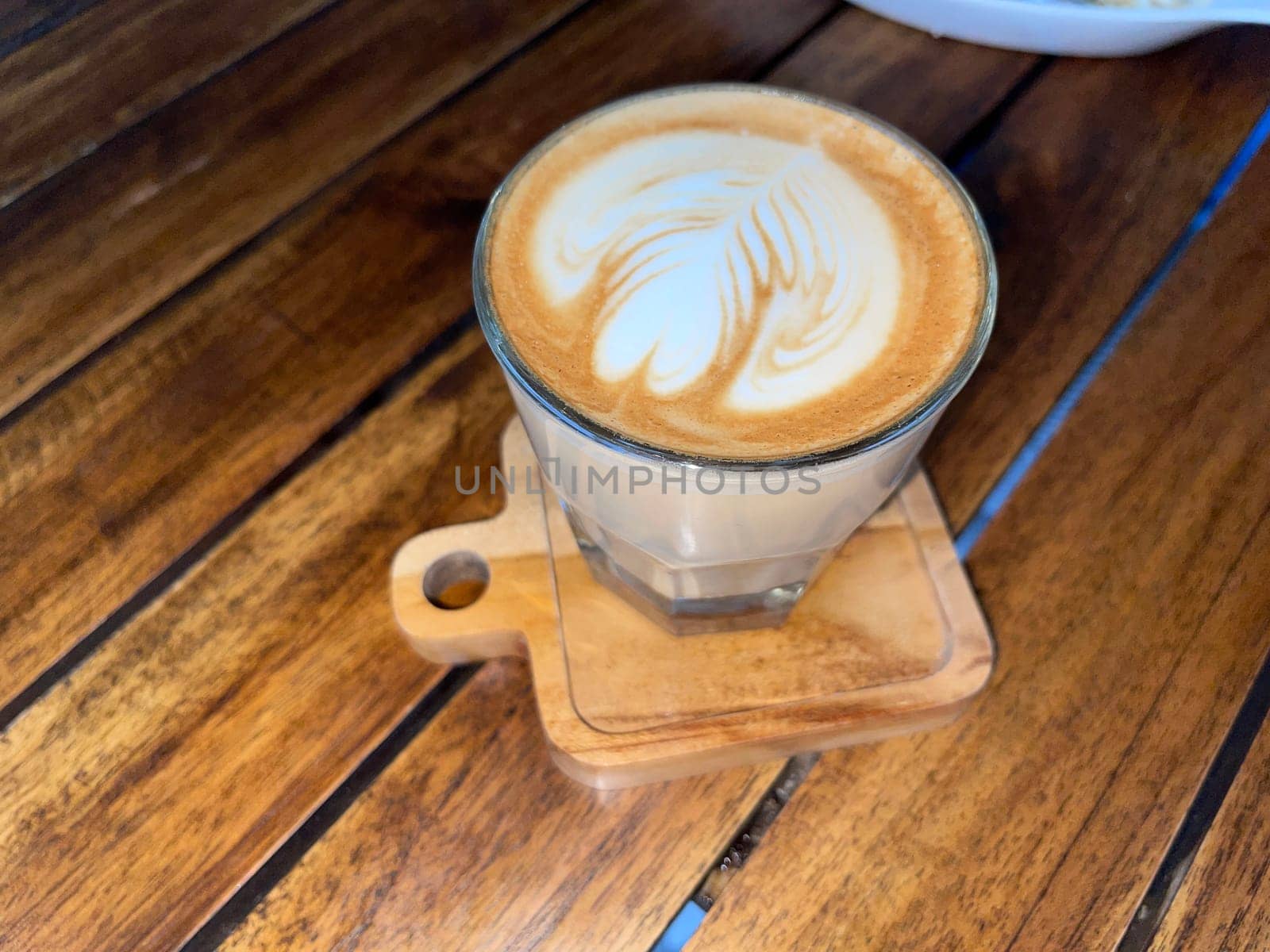 beautiful cup of cappuccino coffee with latte art in the wooden space background