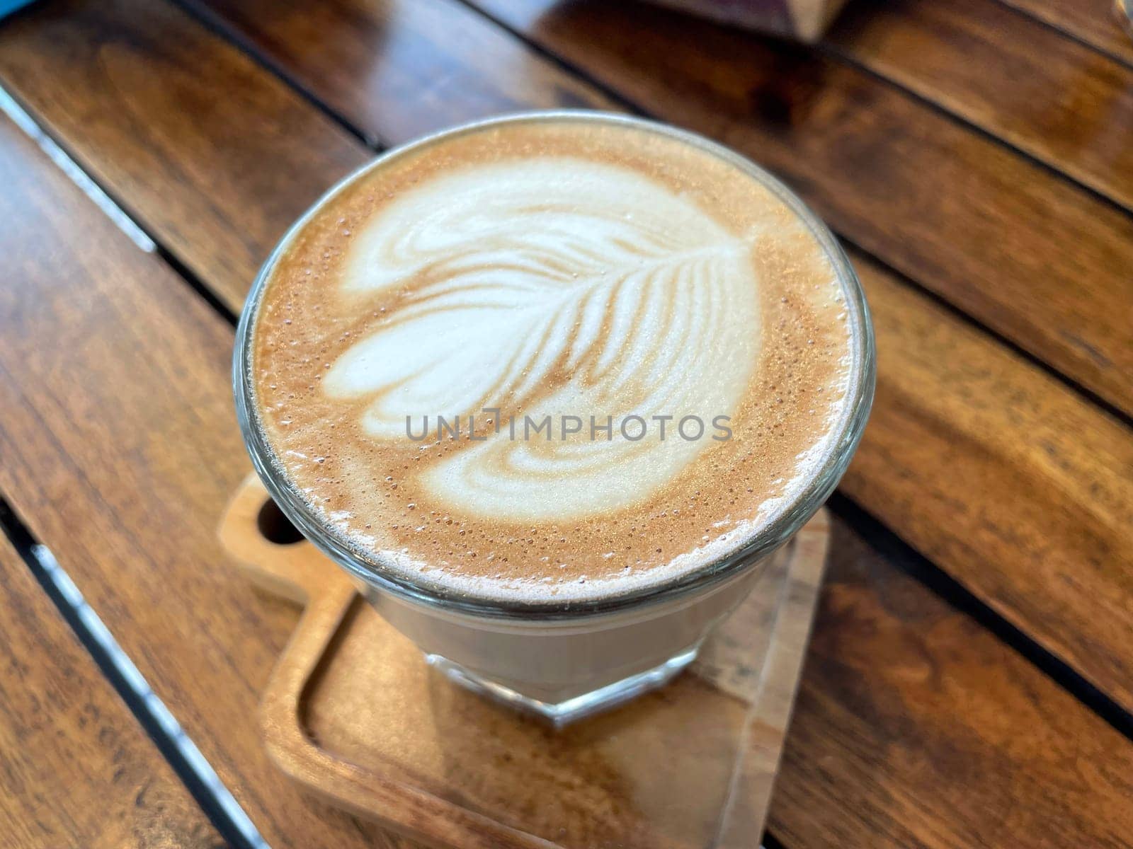 beautiful cup of cappuccino coffee with latte art in the wooden space background