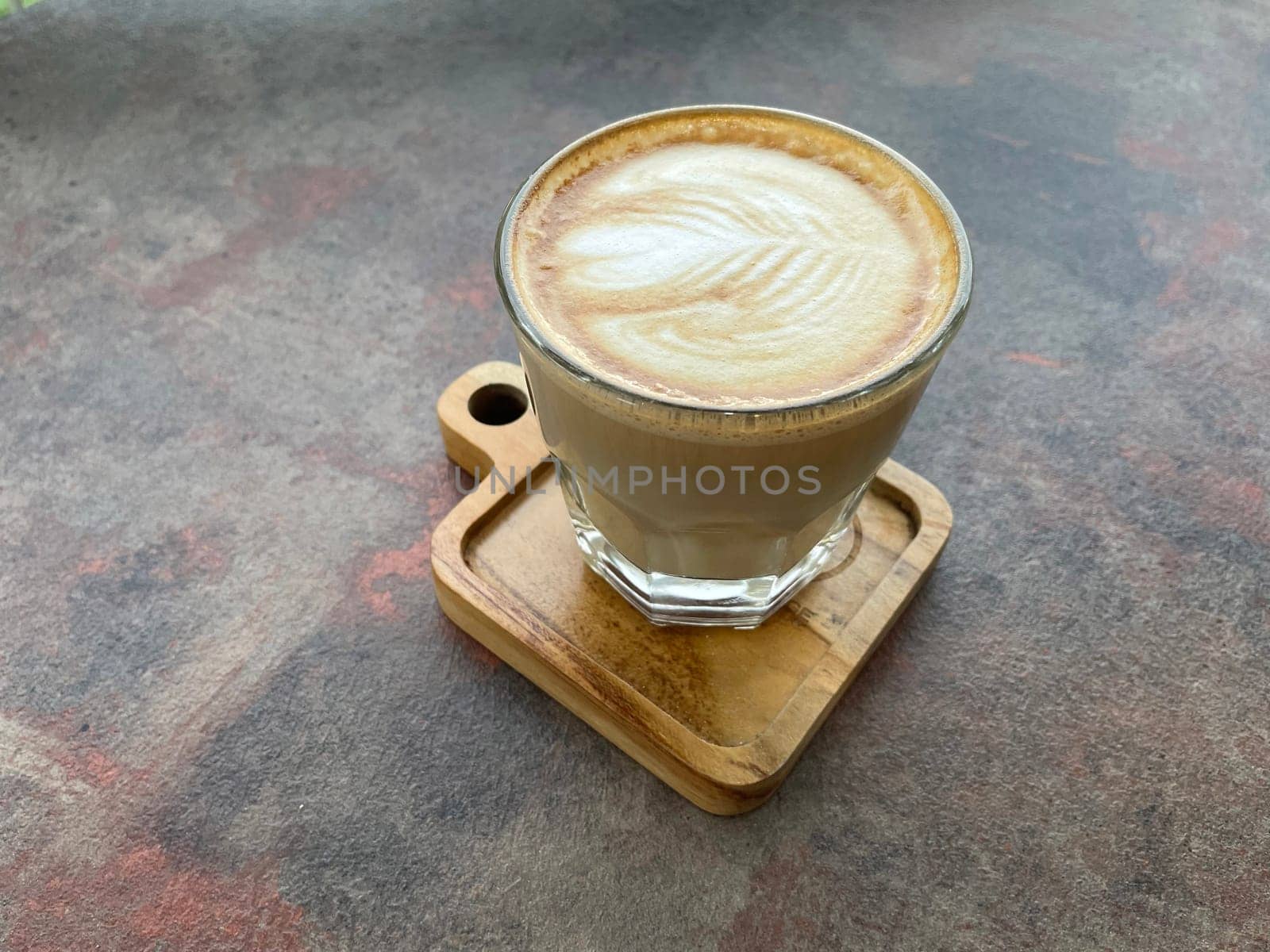 beautiful cup of cappuccino coffee with latte art in the wooden space background by antoksena