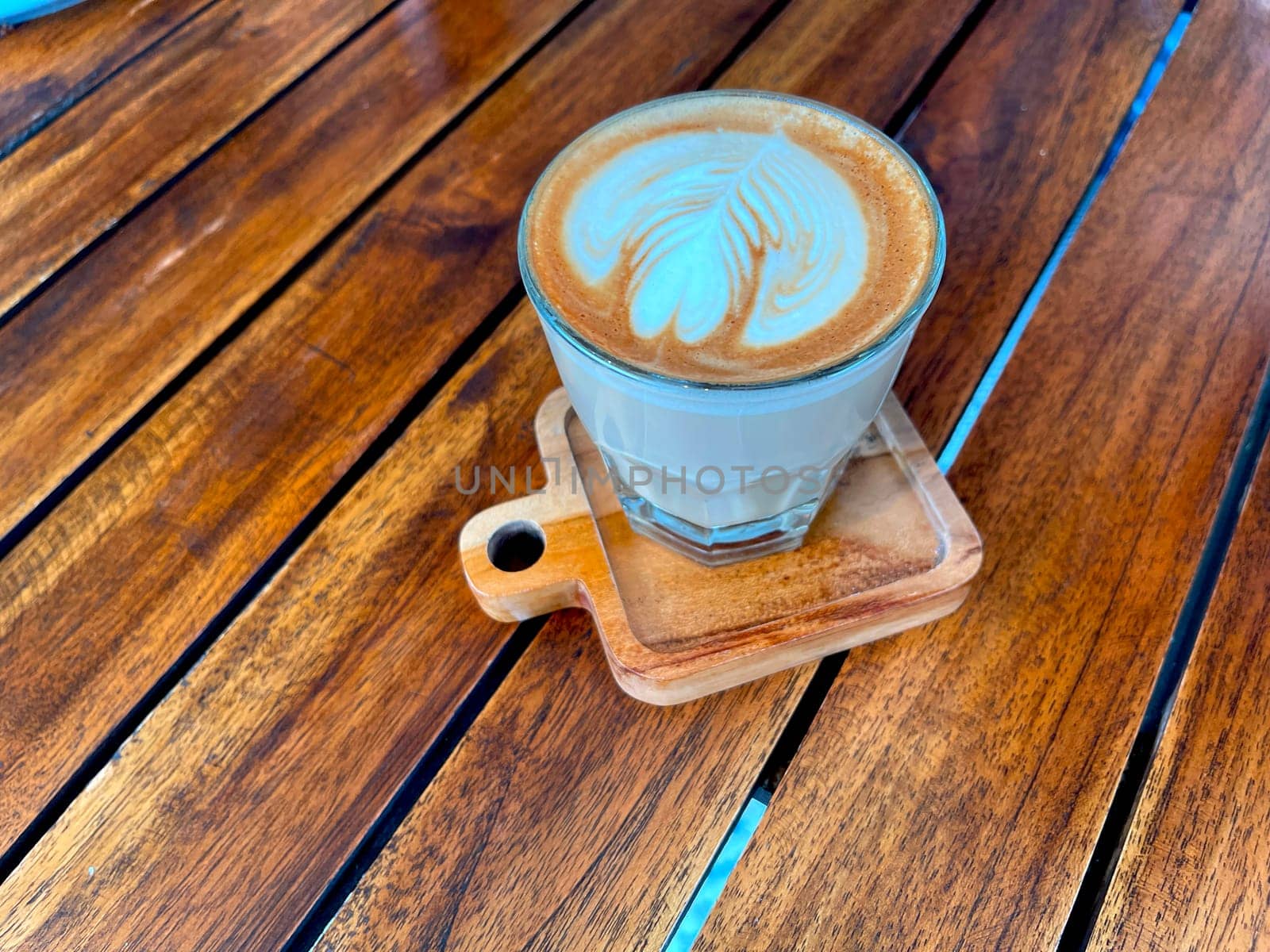 beautiful cup of cappuccino coffee with latte art in the wooden space background