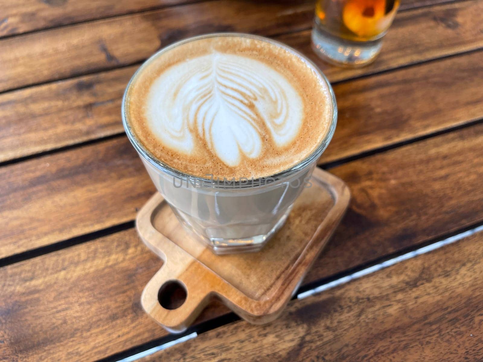 beautiful cup of cappuccino coffee with latte art in the wooden space background by antoksena