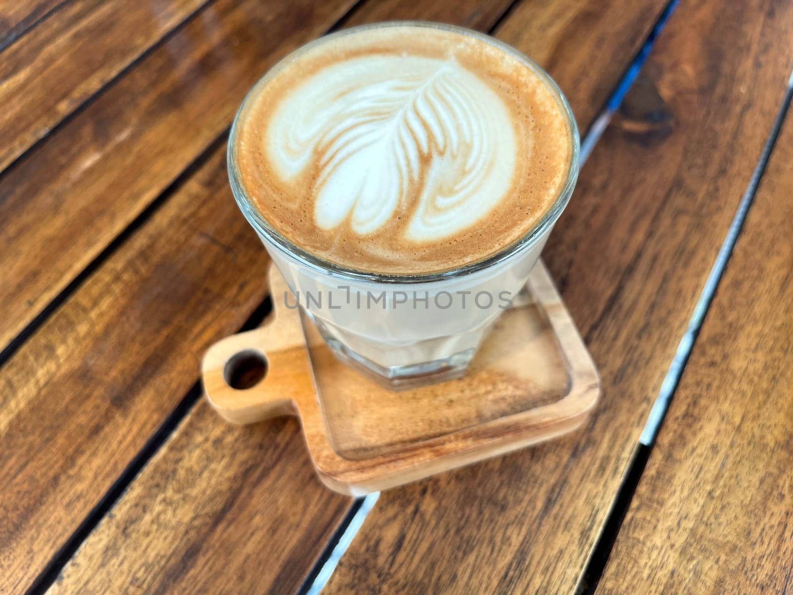 beautiful cup of cappuccino coffee with latte art in the wooden space background by antoksena