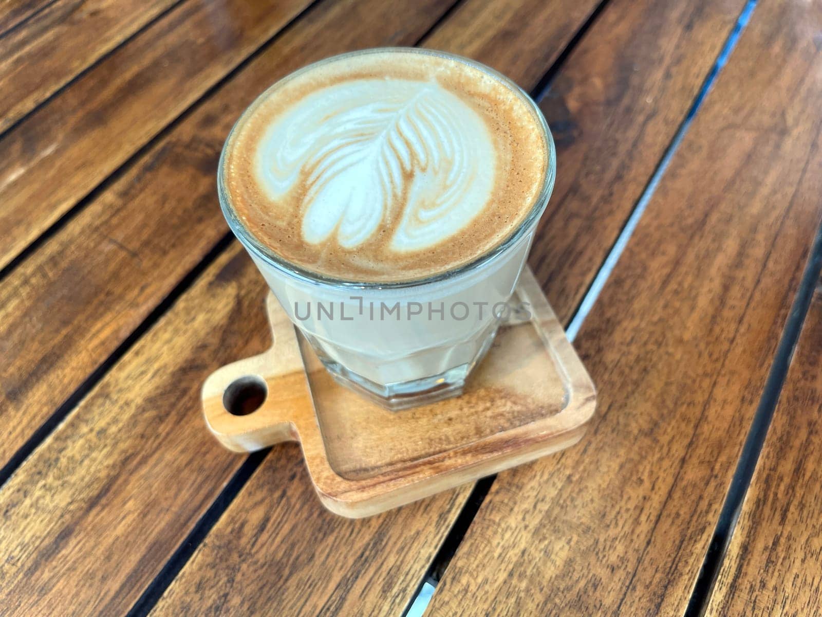 beautiful cup of cappuccino coffee with latte art in the wooden space background by antoksena