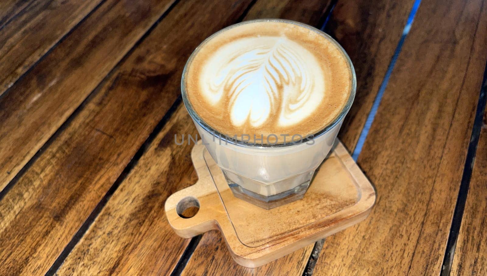 beautiful cup of cappuccino coffee with latte art in the wooden space background