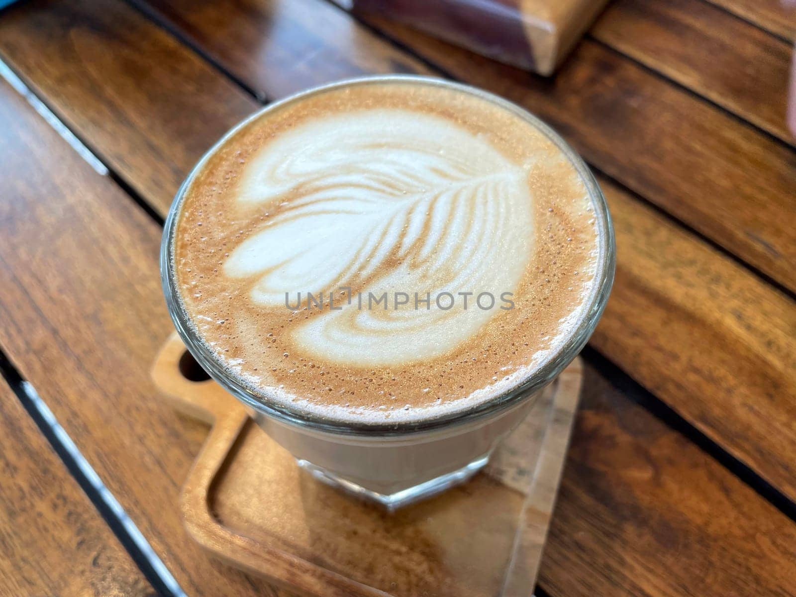 beautiful cup of cappuccino coffee with latte art in the wooden space background