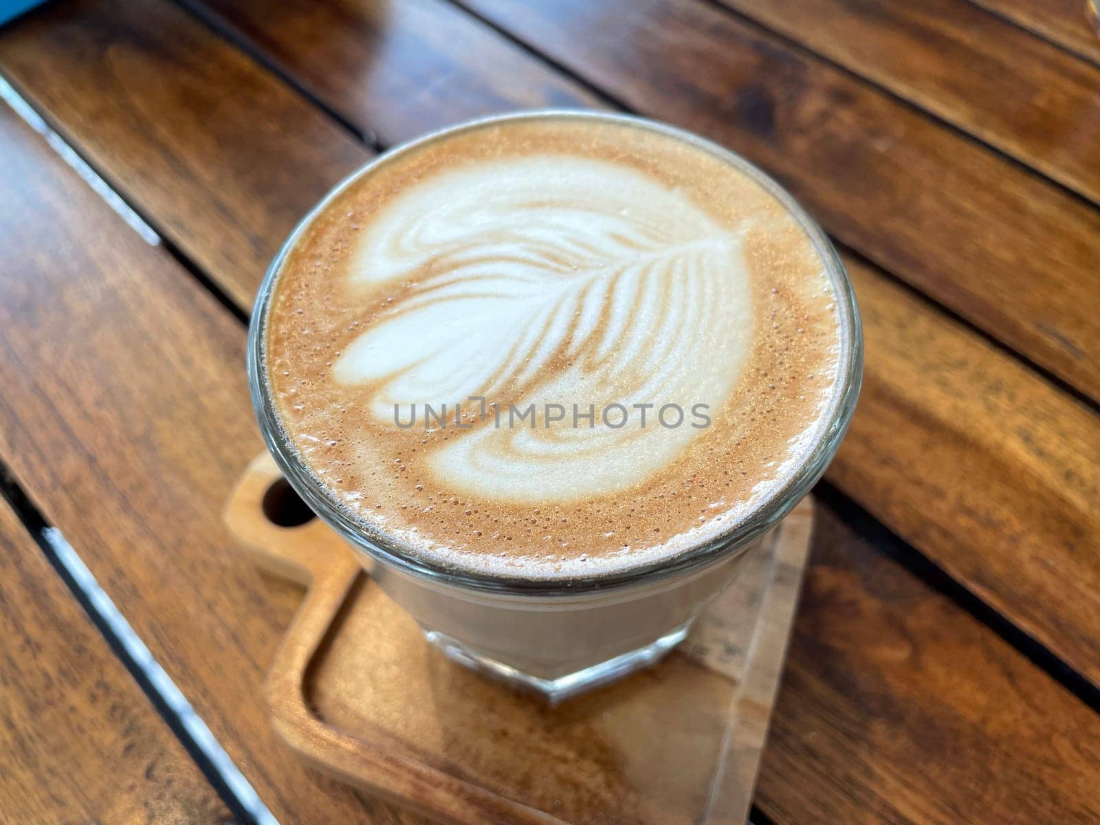 beautiful cup of cappuccino coffee with latte art in the wooden space background