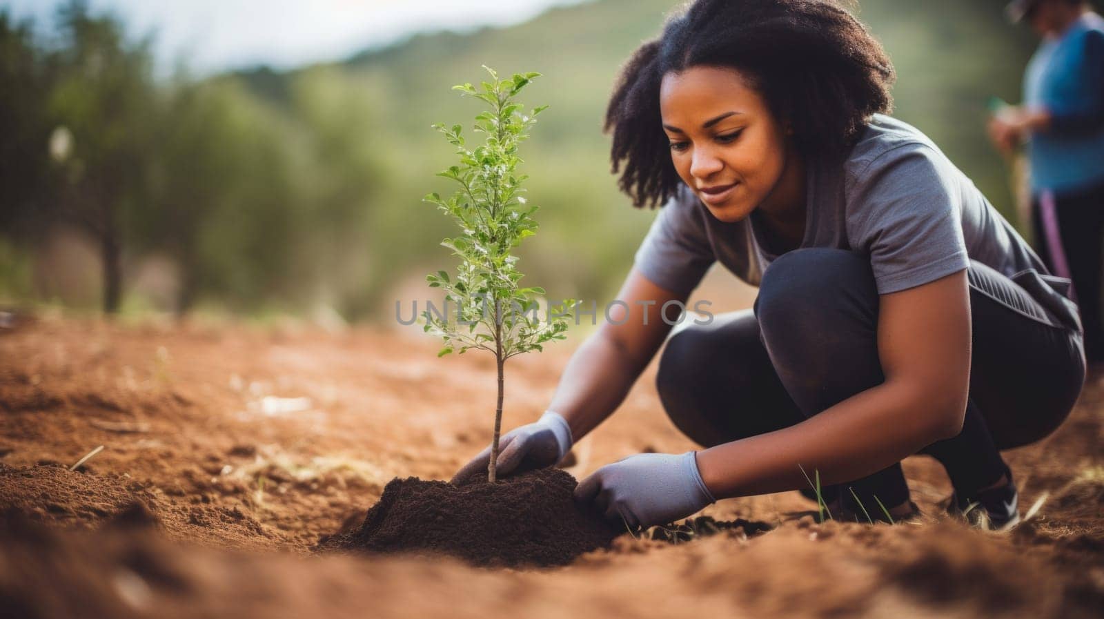 Happy afro american girl planting a tree. Earth protection and sustainability concept.