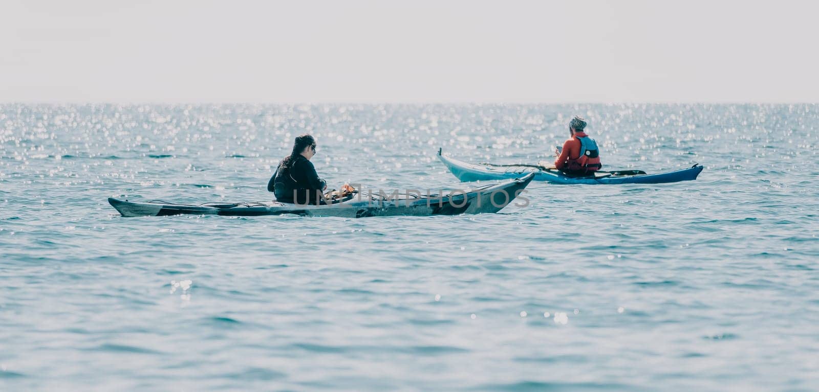 Man woman sea kayak. Happy free man and woman in kayak on ocean, paddling with wooden oar. Calm sea water and horizon in background. Active lifestyle at sea. Summer vacation. by panophotograph