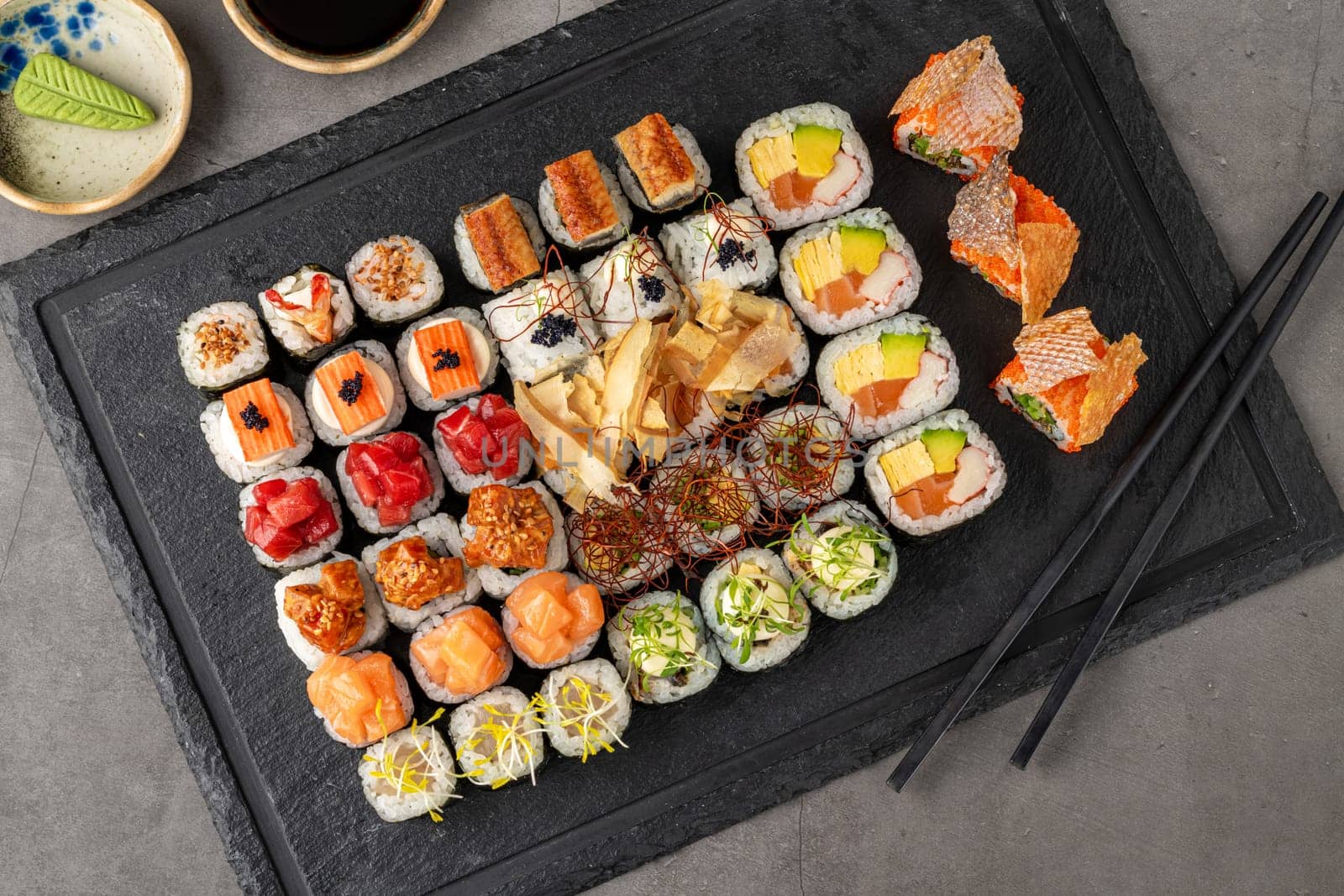 Sushi set of various products on a black stone plate by Sonat