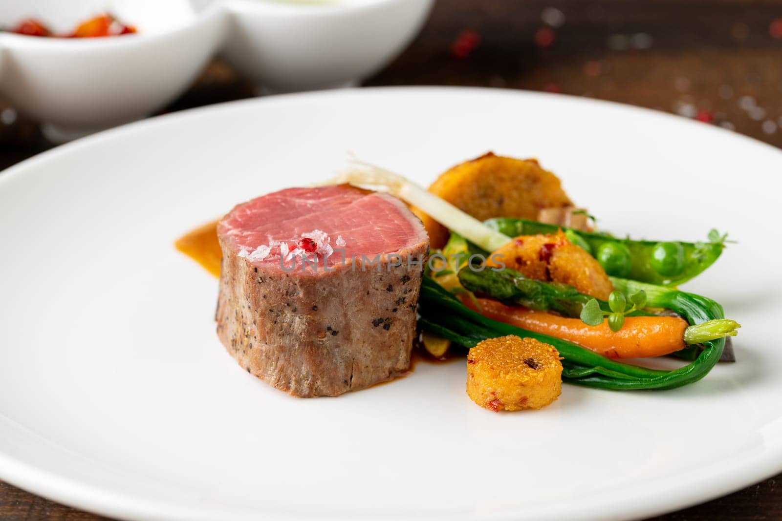 Filet mignon served with vegetables and sauces at a fine dining restaurant