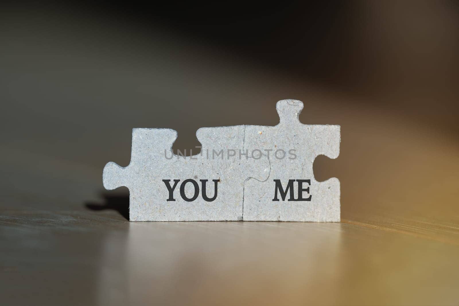 Macro photo of two jigsaw puzzles with you and me words on it. Love or friendship concept. by DariaKulkova
