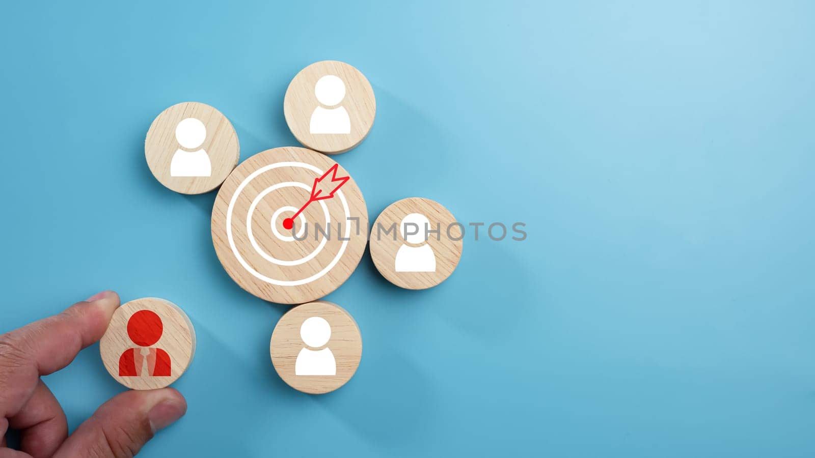 Circular wood with printed target icons and business symbols on light blue background, business goals and objectives concept, business competition, Customer relationship management concept. by Unimages2527