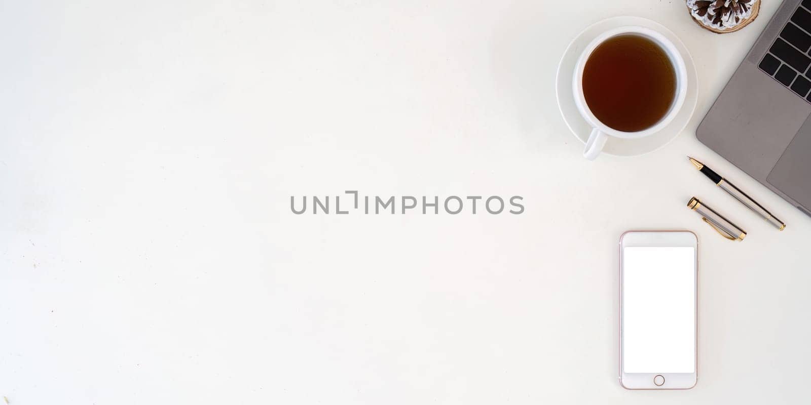 Top view smartphone with empty screen, Laptop and coffee cup on office desk. Copy space for your text by nateemee