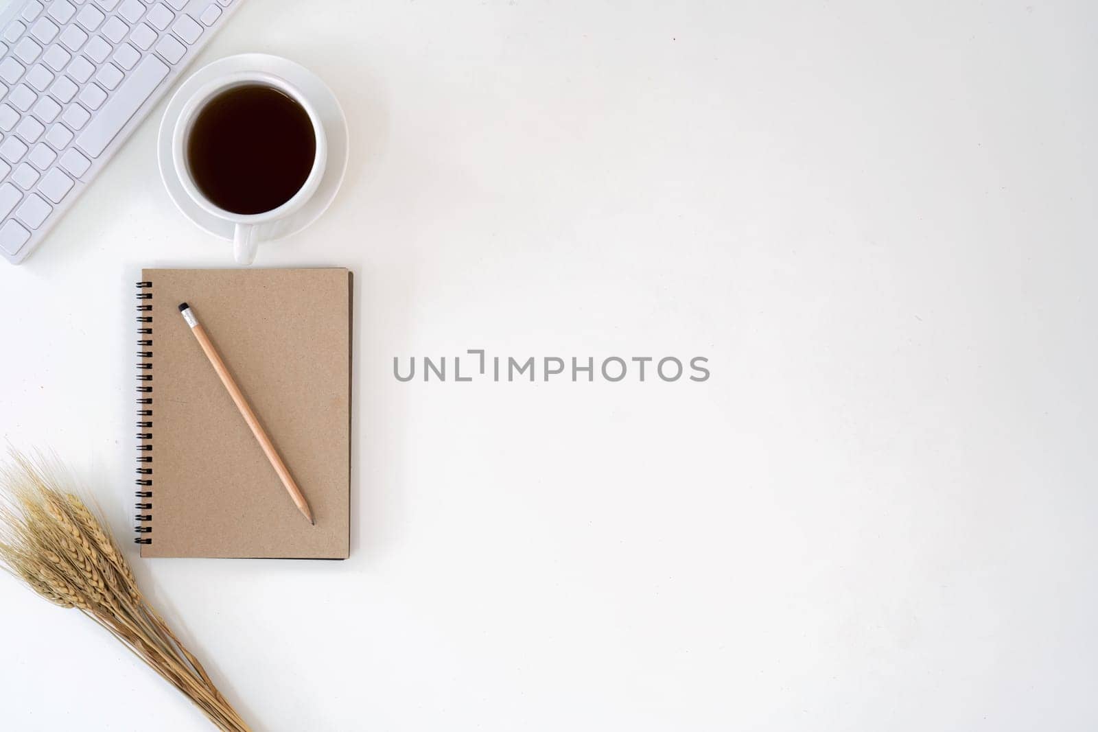 Top view with copy space for your text. keyboard, cup of coffee and notebook on white background by nateemee